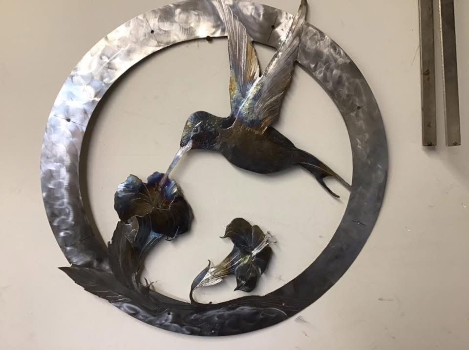 Metal hummingbird wall art in circular frame