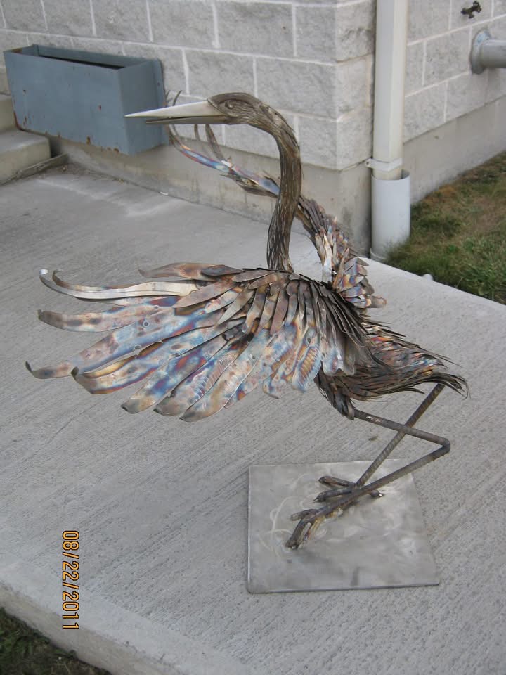Metal heron sculpture with open wings