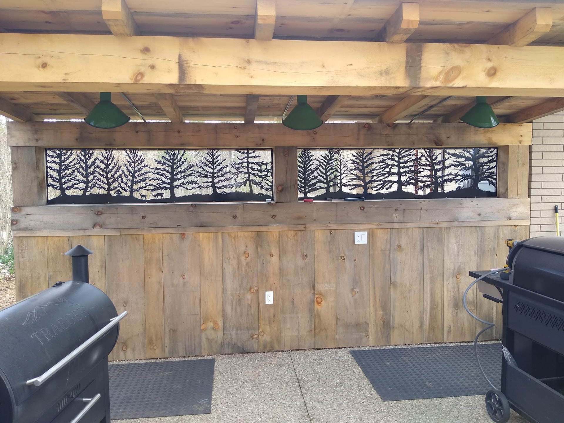 Tree silhouette metal panels as outdoor kitchen accent screens