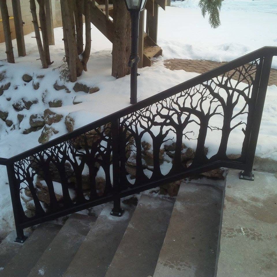 Black metal tree silhouette railing installed in a snowy landscape