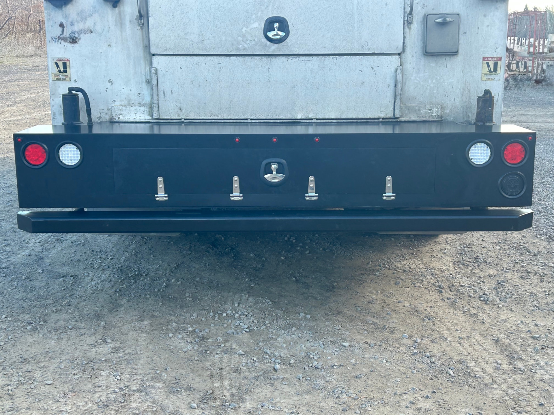 Rear view of custom fabricated truck bumper with red and white lights
