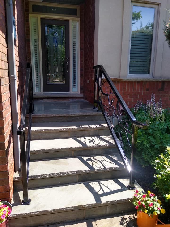 Decorative black metal railings on stone front steps