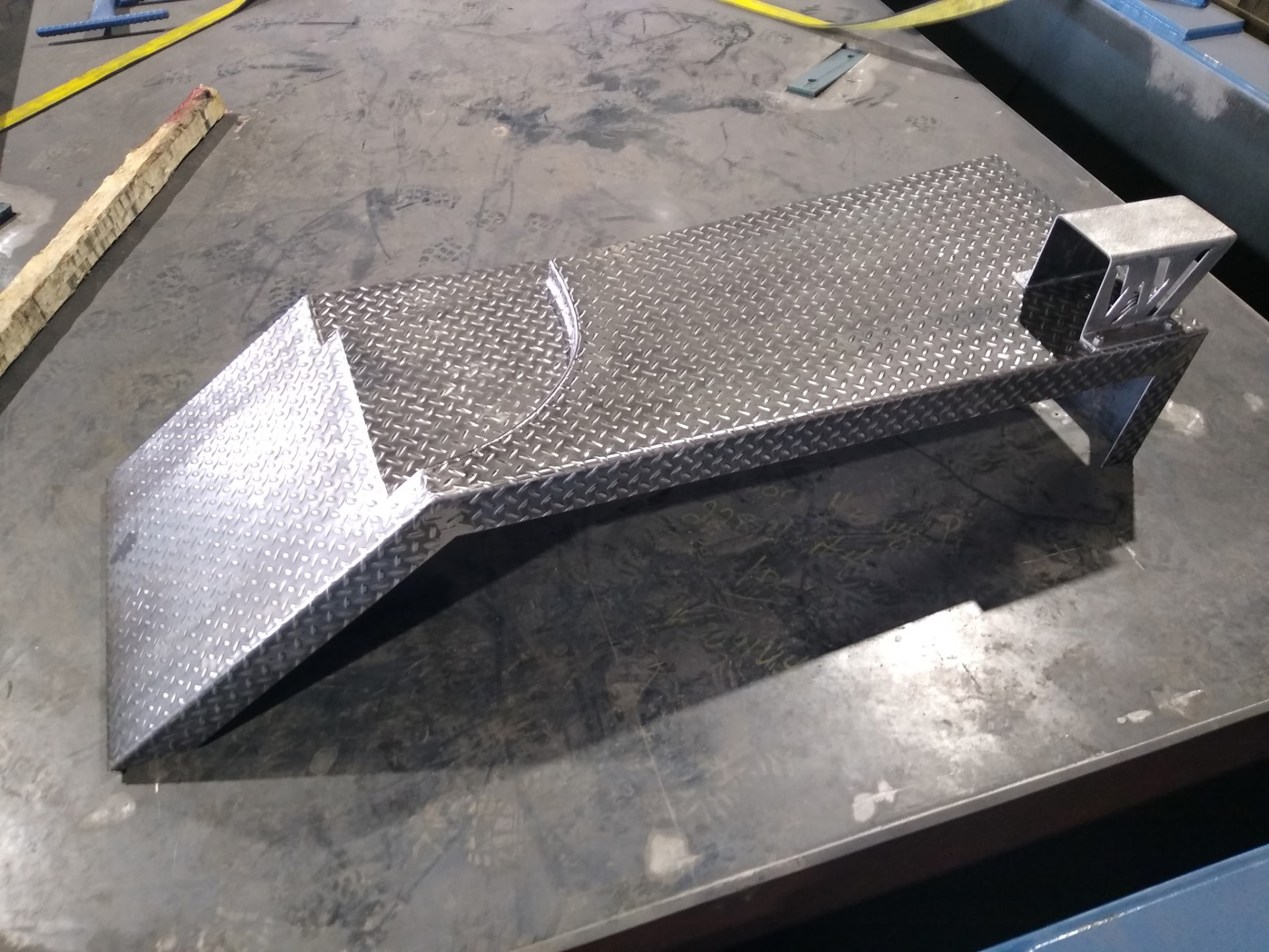 Curved diamond plate fender on fabrication table